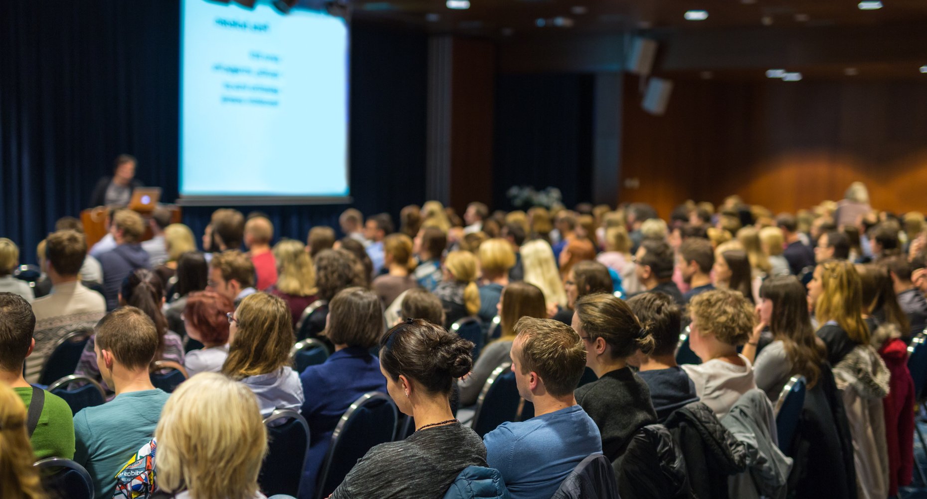 Audience in Lecture Hall Participating at Business Event